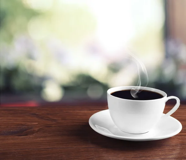 Kopje koffie op tabel op lichte achtergrond — Stockfoto