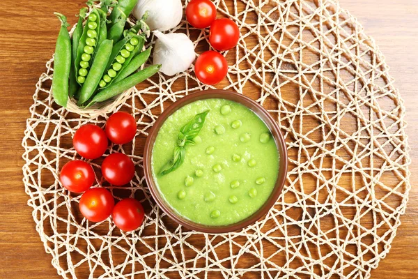 Sopa de ervilhas saborosas e legumes na mesa de perto — Fotografia de Stock
