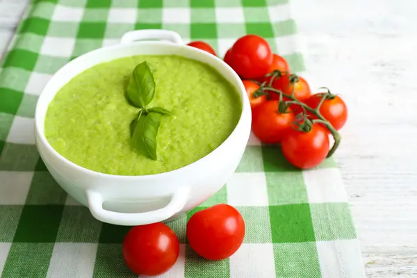 Tasty peas soup and cherry tomatoes on table close up — Stock Photo, Image