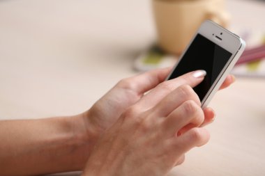 Çalışma alanı üzerinde mobil telefon kullanan kadın yakın çekim