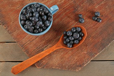 Kupası ve ahşap masa kaşık taze yaban mersini yakın çekim