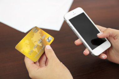 Kadın ahşap masa arka plan üzerinde mobil bankacılık uygulaması ile smartphone cep telefonu ile hesap bakiyesi doğrular