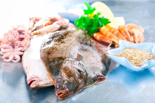 Färska fiskar och räkor med kryddor på metall bakgrund — Stockfoto