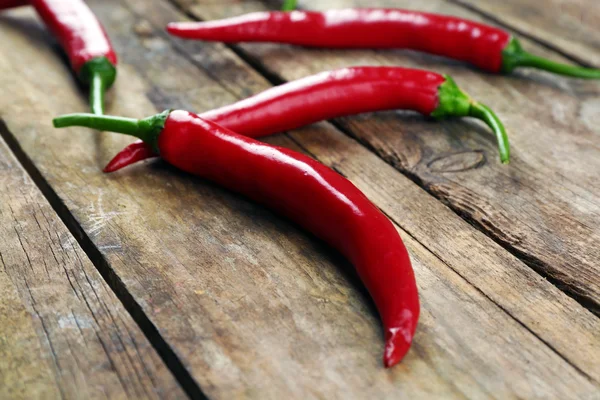 Pimientos rojos picantes en mesa de madera de cerca — Foto de Stock