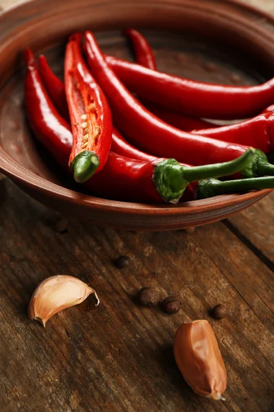 Hete pepers met kruiden op houten tafel close-up — Stockfoto