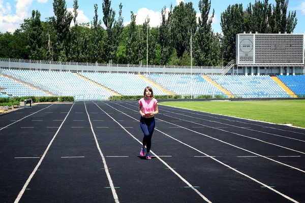 Молодая женщина бегает по стадиону — стоковое фото