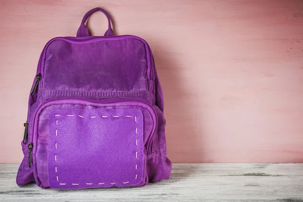 Ahşap arka plan üzerinde okul sırt çantası