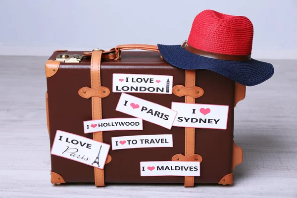 Suitcase with stickers on floor in room — Stock Photo, Image