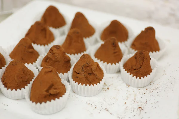Deliciosos doces de chocolate no prato de perto — Fotografia de Stock