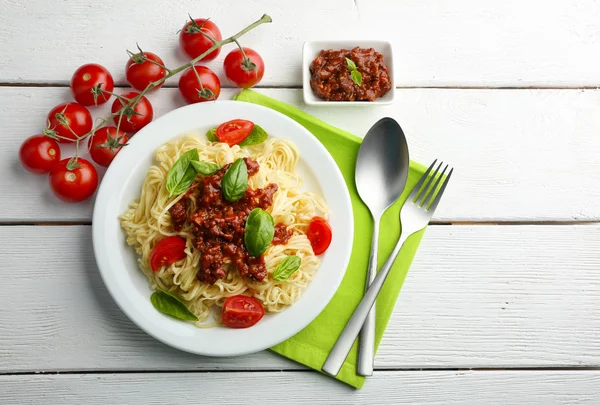 Spaghetti Boloñesa sobre plato blanco, sobre fondo de madera de color — Foto de Stock