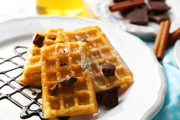 Sweet homemade waffles with chocolate sauce on plate, on light background — Stock Photo, Image