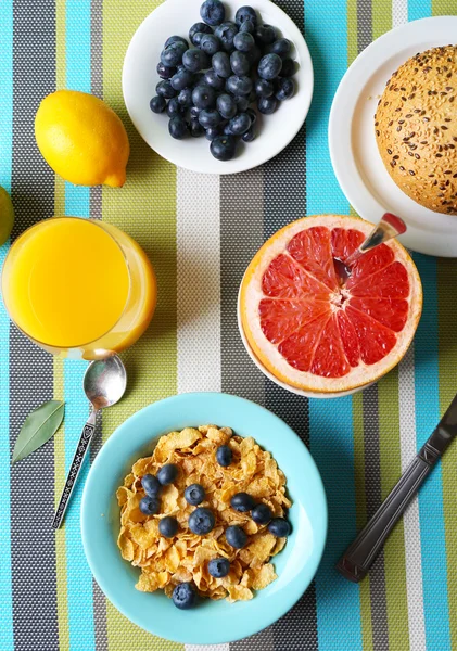 Tasty cornflakes with fruits and berries on table close up — Stock Photo, Image