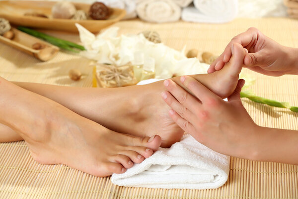 Masseur making feet massage in spa salon