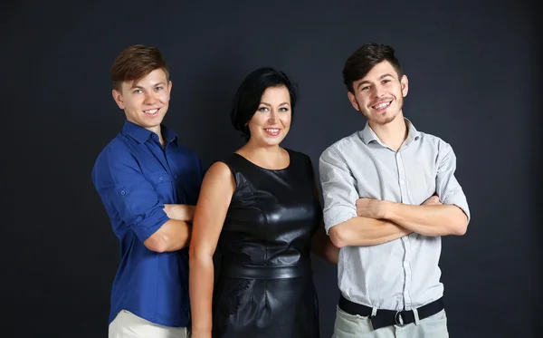 Portrait of mother and her sons on dark background — Stock Photo, Image