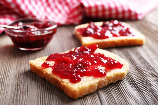 Bread with butter and homemade jam on wooden table, closeup — Stock Photo, Image