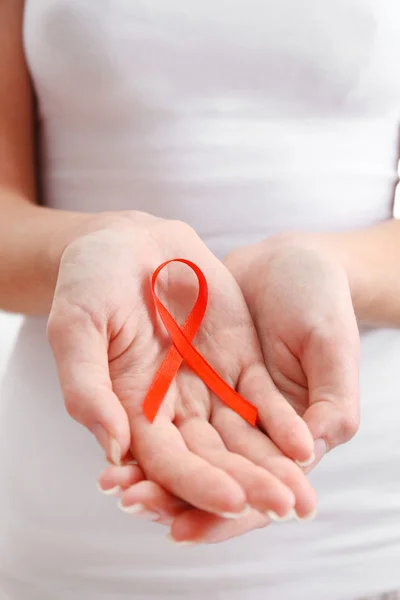 Female hands holding red ribbon sign, closeup — Stock Photo, Image