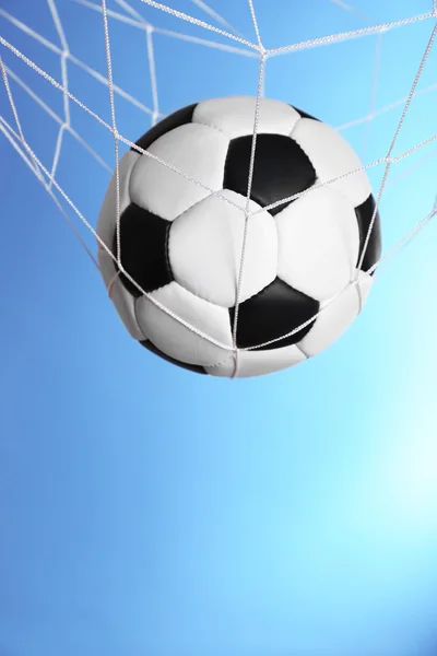 Fotboll i nätet på blå bakgrund — Stockfoto