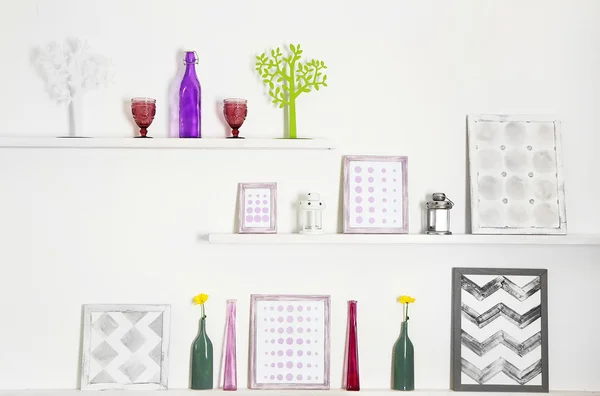 Diferentes objetos de casa e decoração em prateleiras no fundo da parede branca — Fotografia de Stock