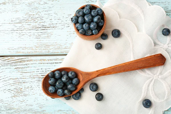 Fresh blueberries in spoon and bowl on table close up — Stock Photo, Image
