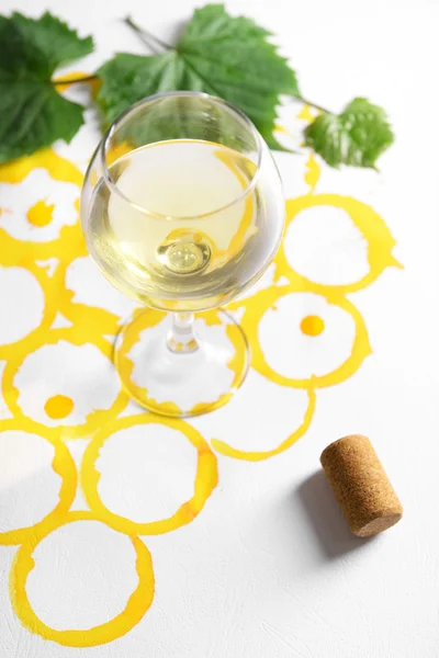 Wine goblet and corks on picture painted with wine — Stock Photo, Image