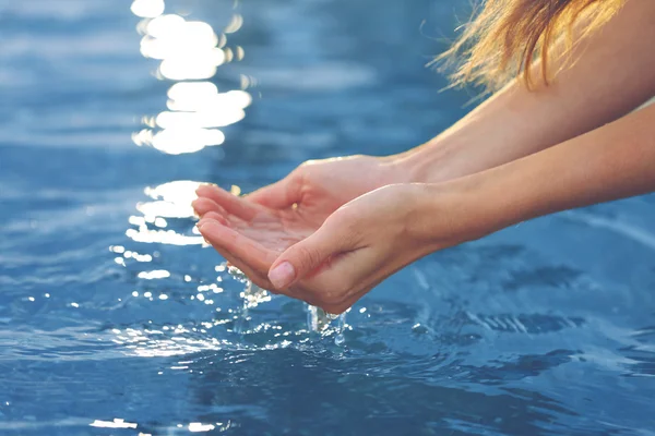 Mani femminili toccano l'acqua di mare — Foto Stock