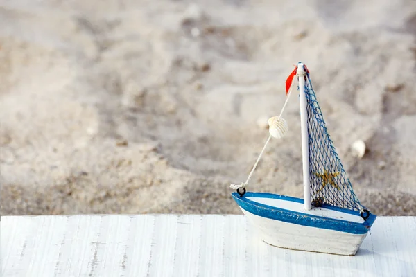 Pequeño barco sobre arena playa fondo — Foto de Stock