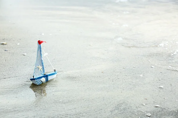 Kleines Schiff auf Sandstrand Hintergrund — Stockfoto