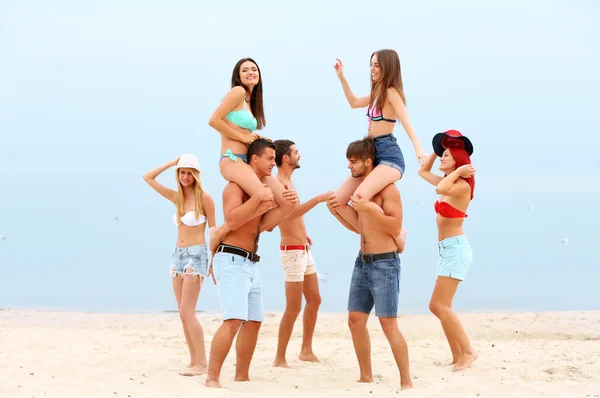 Jovens bonitos se divertindo na praia — Fotografia de Stock