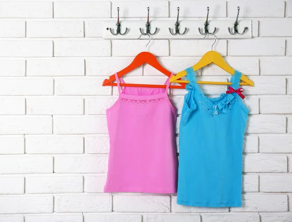 Child clothes on hanger on white wall background — Stock Photo, Image