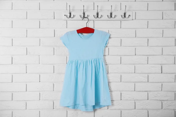 Φόρεμα παιδί σε κρεμάστρα σε φόντο λευκό τοίχο — Φωτογραφία Αρχείου