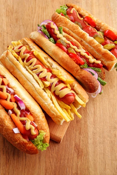Hot dog freschi sul tagliere su sfondo di legno — Foto Stock