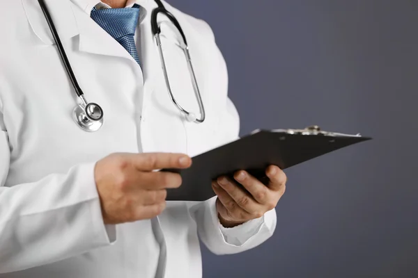 Docteur avec presse-papiers sur fond bleu — Photo