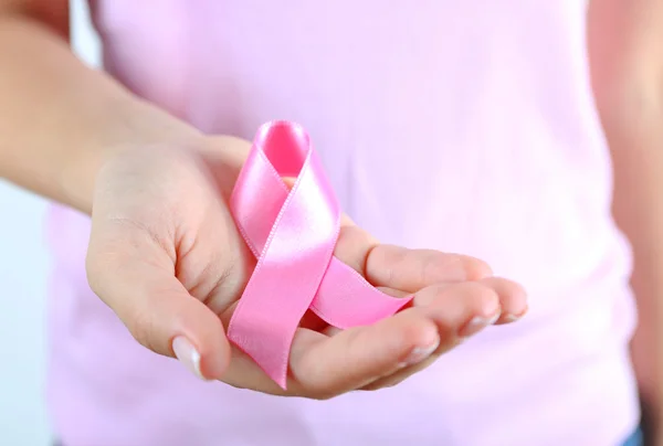 Roze lint in handen van de vrouw close-up — Stockfoto