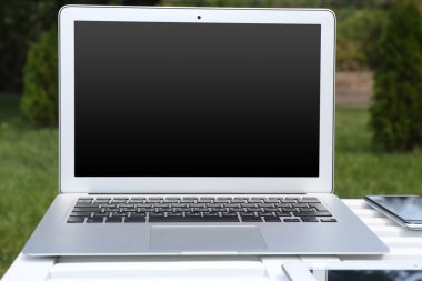 Laptop ve ahşap masa kağıtlara