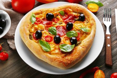 Ahşap arka plan tabakta servis pizza kalp şeklinde