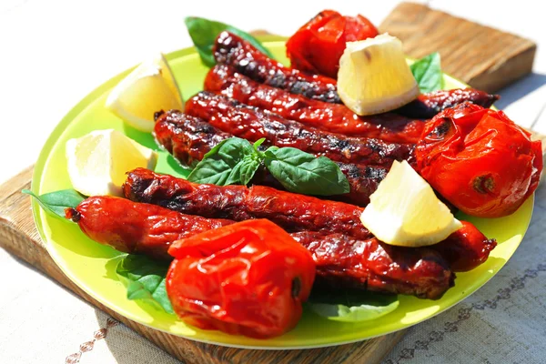 Embutidos a la parrilla con verduras en primer plano — Foto de Stock