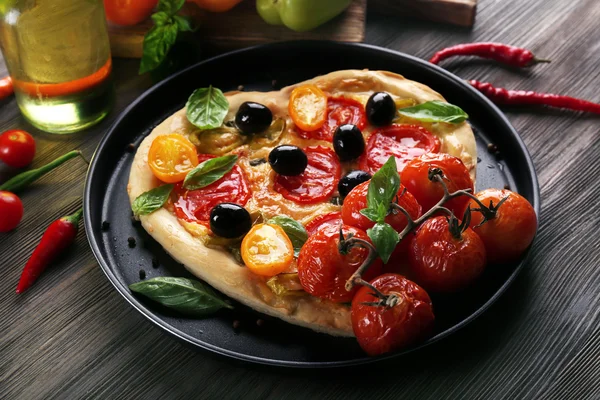 Heart shaped pizza on metal tray on wooden table — Stock Photo, Image