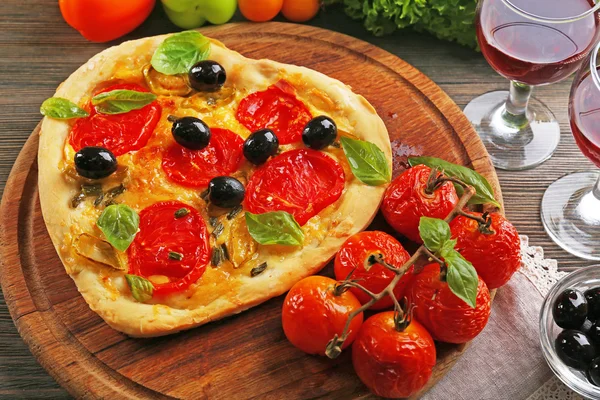 Heart shaped pizza served with wine on wooden table — Stock Photo, Image