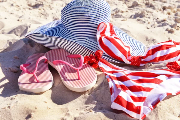 Chanclas, traje de baño y sombrero en la playa —  Fotos de Stock