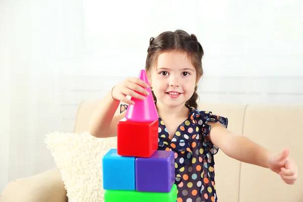 Niña jugando con cubos en el fondo interior de casa —  Fotos de Stock