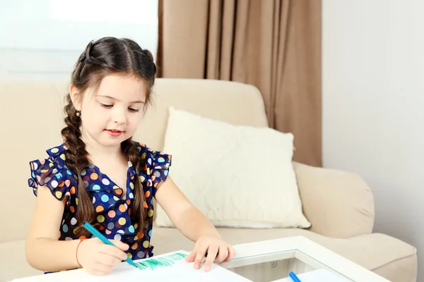 Милая маленькая девочка рисует картину на домашнем фоне интерьера — стоковое фото