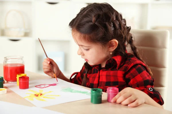 Schattige kleine meisje schilderij beeld op huis interieur achtergrond — Stockfoto