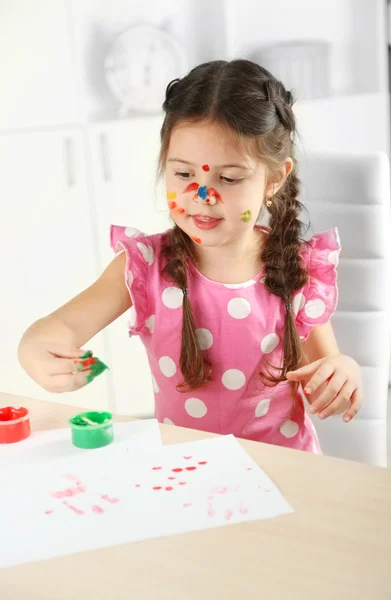 Cute little girl painting picture on home interior background — Stock Photo, Image