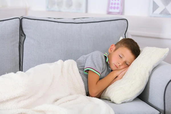 Lille pojken sover på soffan i rummet — Stockfoto