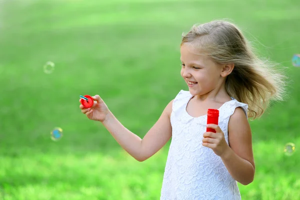 Cute girl blowing soap bubbles — Stock Photo, Image