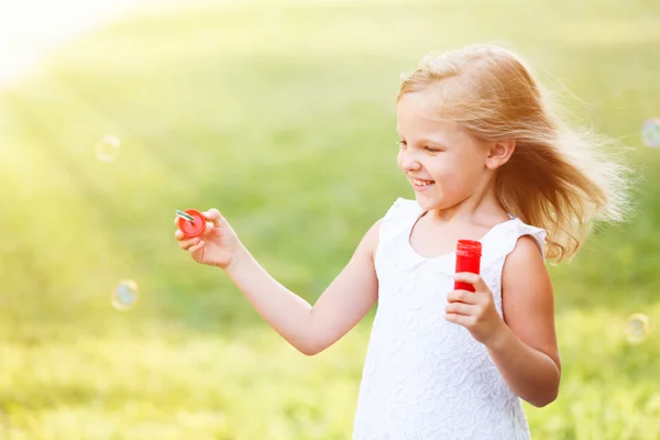 Cute girl blowing soap bubbles — Stock Photo, Image