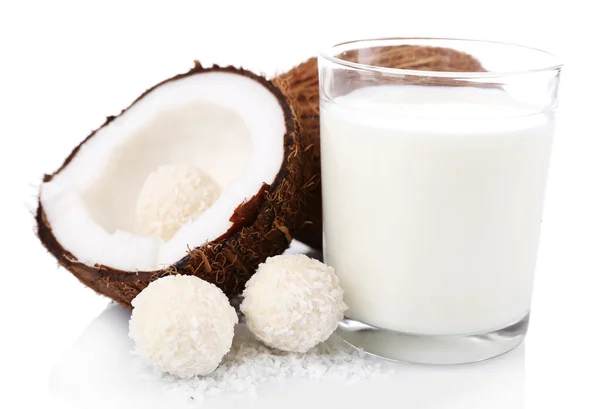 Конфеты в кокосовых хлопьях, стакан молока и свежий кокос изолированы на белом — стоковое фото