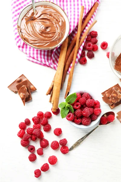 Szép kompozíció csokoládé tejszínnel és a málna — Stock Fotó