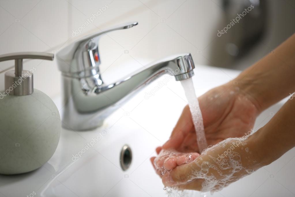 hands with soap under running water