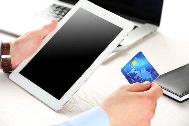 Kredi kartı ve tablet tutan adam